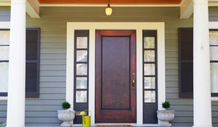 Elegantní vstupní dveře s okny a dekorativními květináči před domem, ideální pro moderní bydlení.